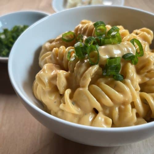 rotelle pasta with gorgonzola buffalo sauce topped with chives in white bowl