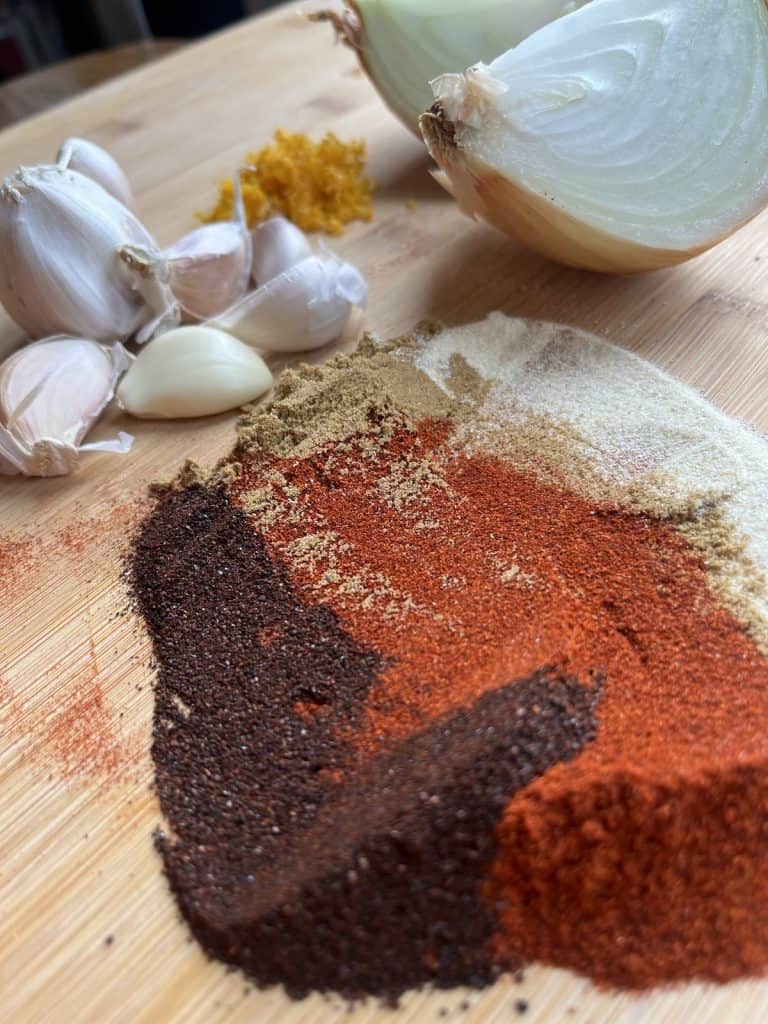 Spices, garlic and onions on a cutting board