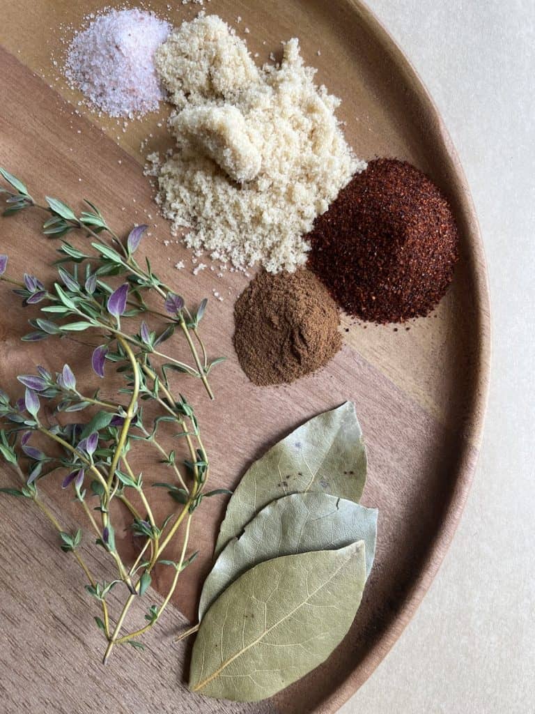 spices, thyme and bay leaves on a wooden plate