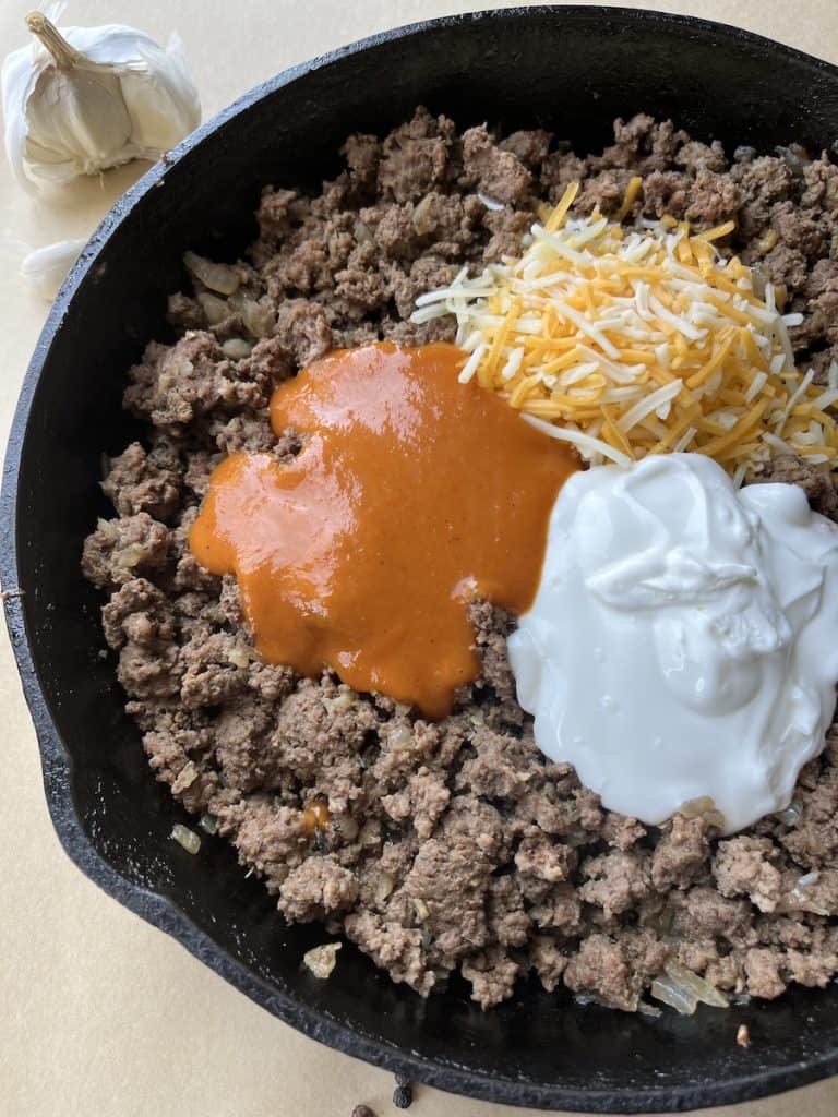 ground beef, cheese, sour cream and tomato sauce in a cast-iron skillet to make Beef Enchiladas with Flour Tortillas