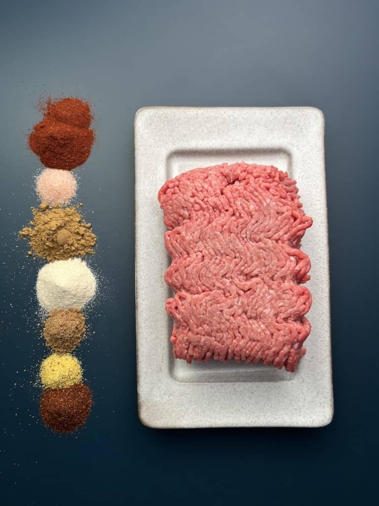 raw ground beef with spices to make ground beef tacos with avocado cilantro aioli