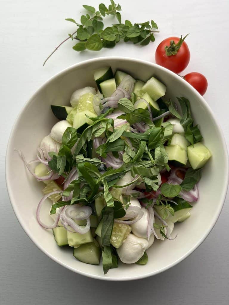 tomato cucumber mozzarella salad in a bowl