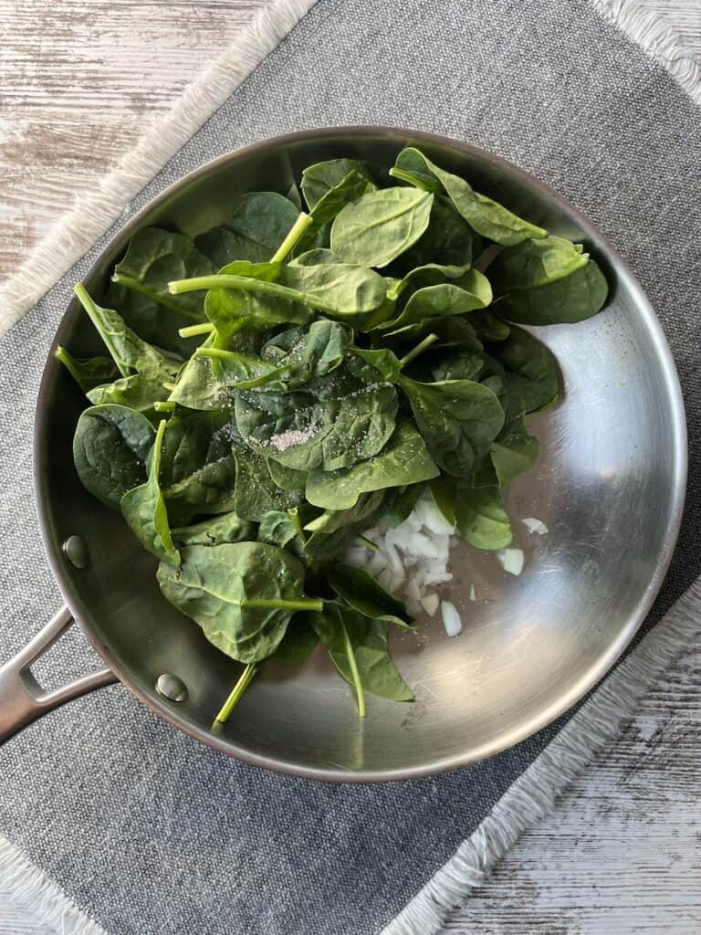 cooked onions and raw spinach to make ham and spinach quiche