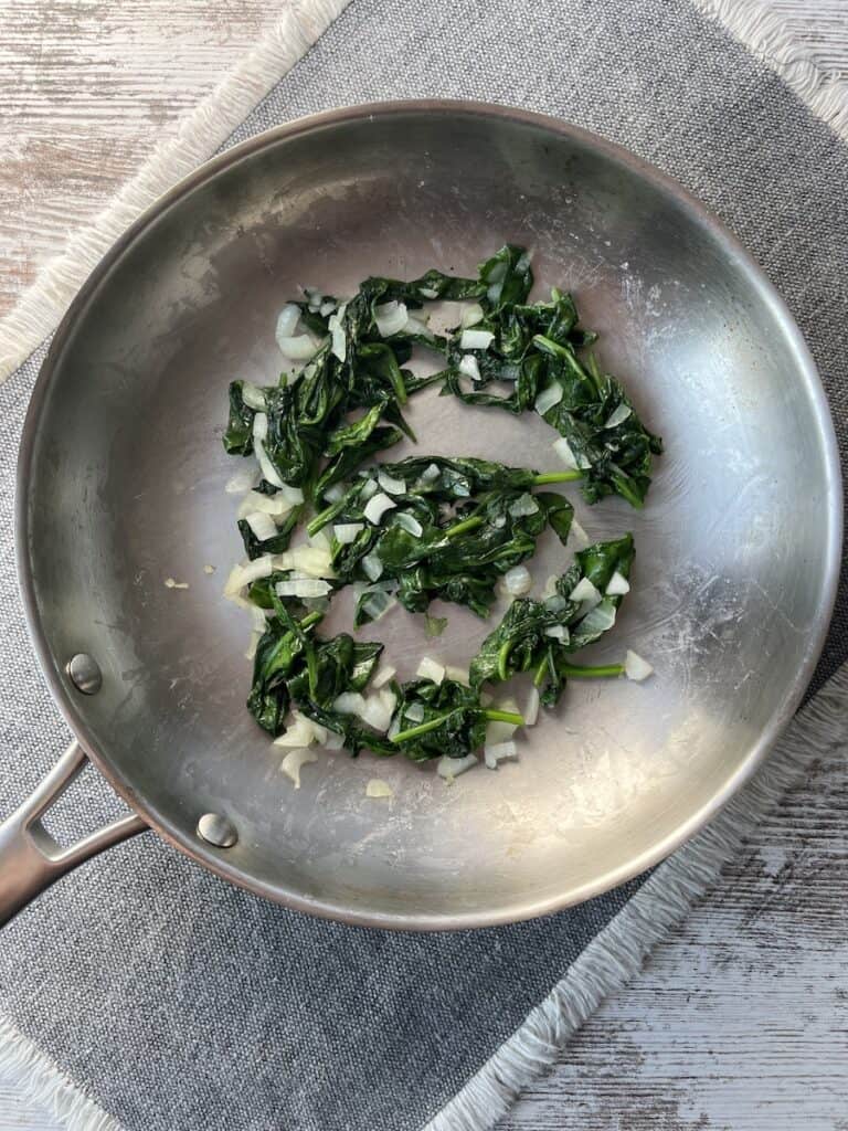 cooked onions and spinach to make ham and spinach quiche