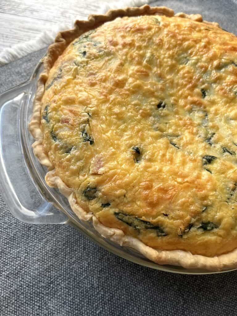 ham and spinach quiche in glass pie pan