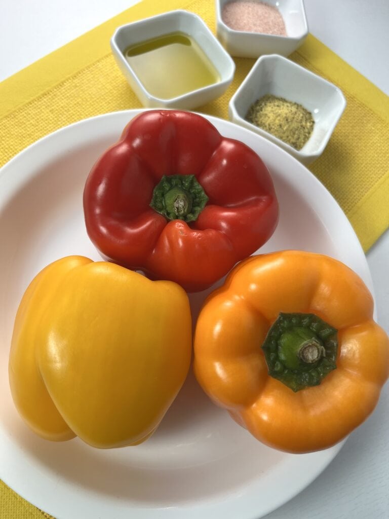 red, yellow, and orange bell pepper in a shallow bowl, oil, sea salt, and lemon pepper in bowls