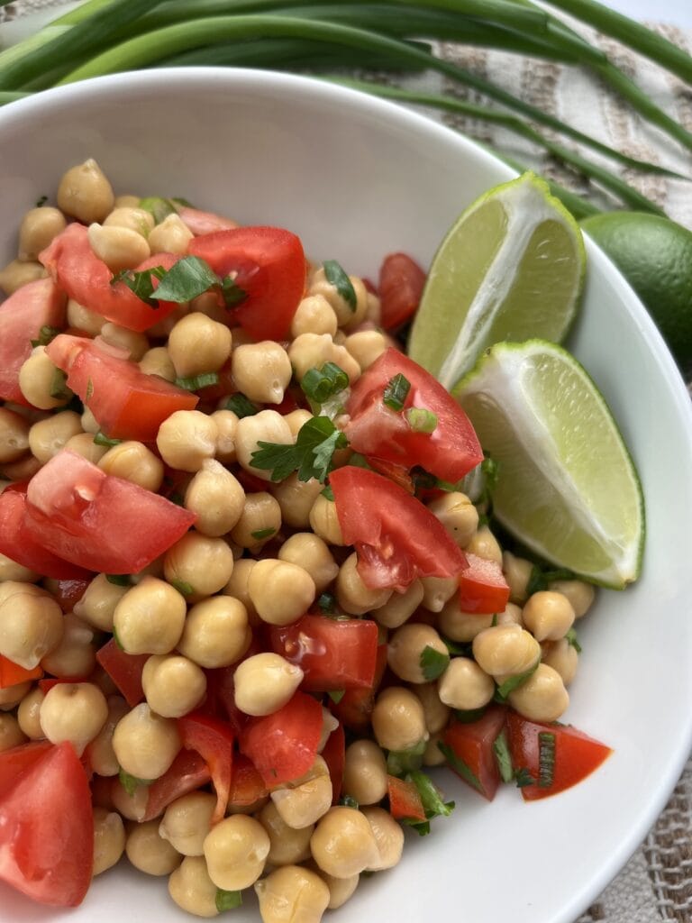 mixed easy chickpea salsa in a bowl with limes