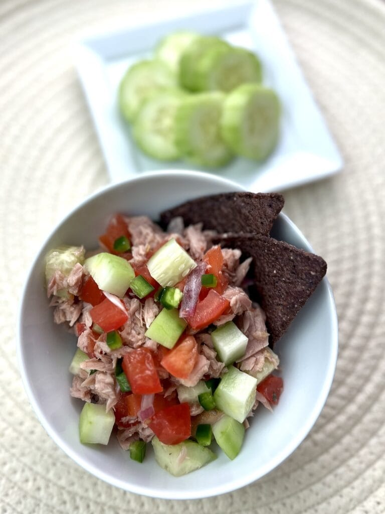 tuna with pico de gallo and cucumbers in a bowl with blue corn chips