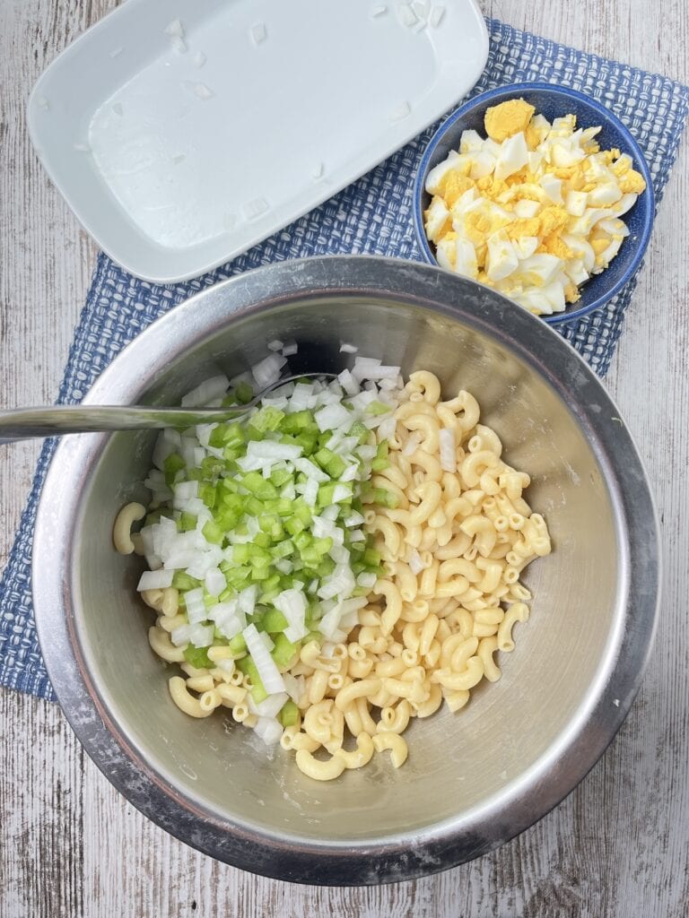 celery, onions, and cooked pasta in a bowl