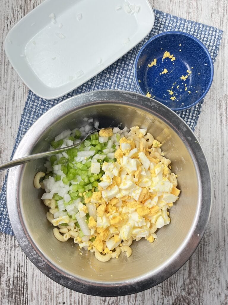 celery, onions, eggs and cooked pasta in a bowl