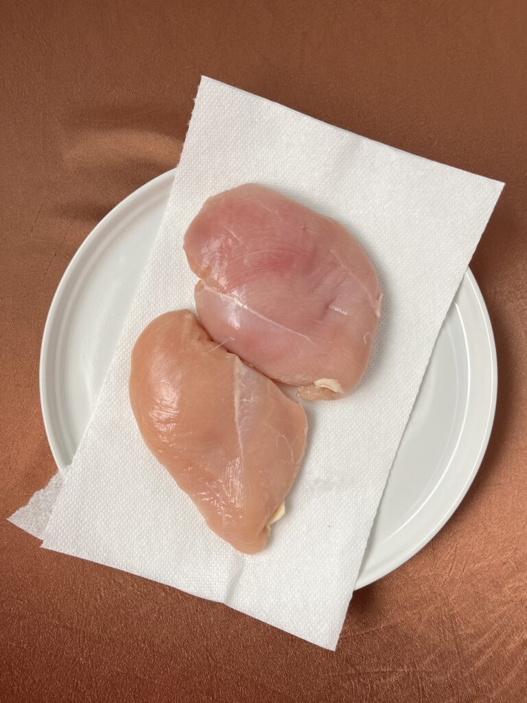 raw chicken breasts on a paper towel