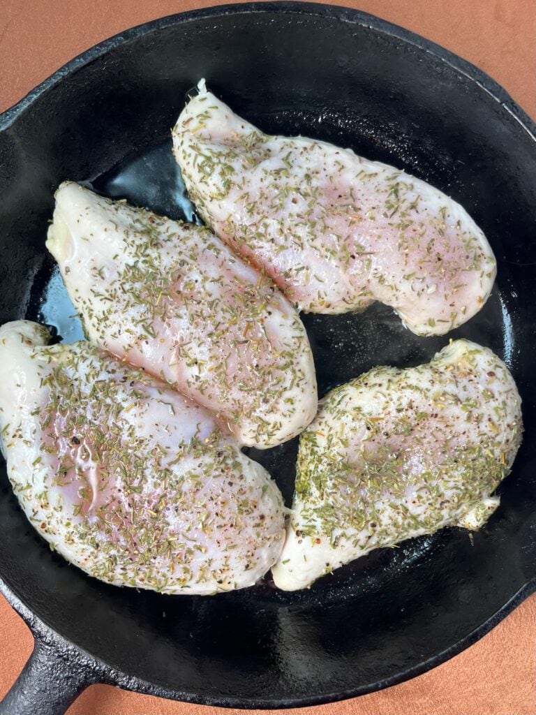 half cooked seasoned chicken in a skillet