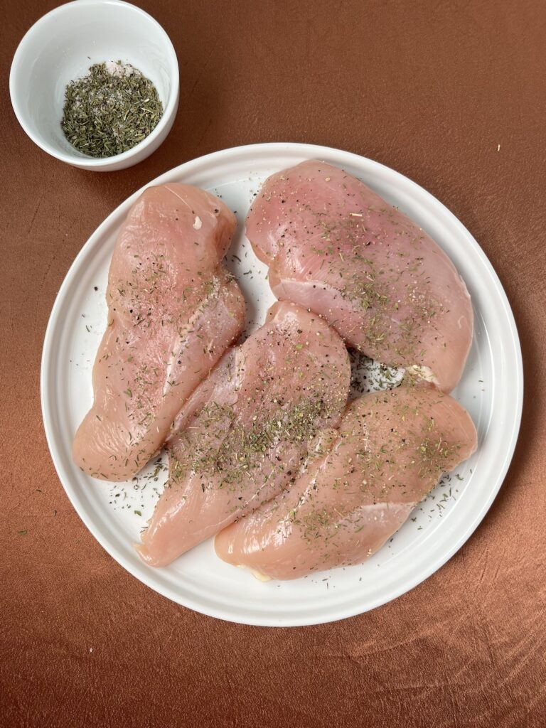 raw seasoned chicken on a plate